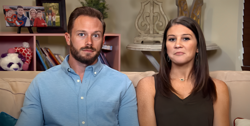 Adam and Danielle Busby sit on sofa speaking to camera on OutDaughtered