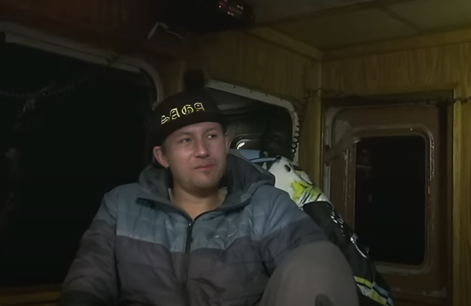 Elliott Neese wears SAGA hat and looks to right on The Saga, wearing a coat on Deadliest Catch.