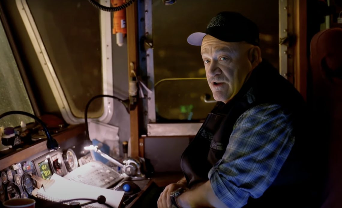 Deadliest Catch captain Keith Colburn sits at helm of boat looking across shot