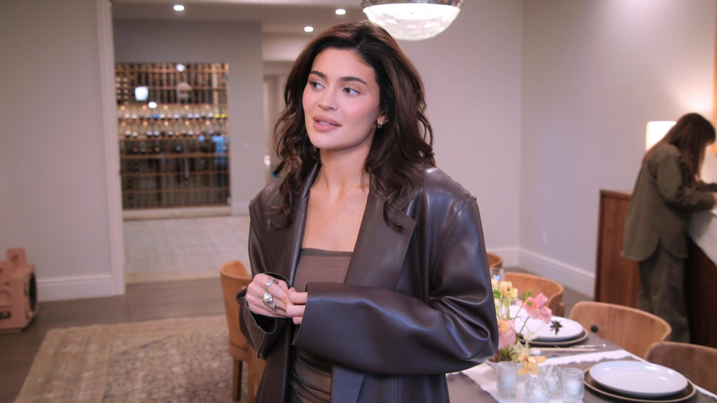 Kylie Jenner looks to left wearing brown leather blazer on The Kardashians.