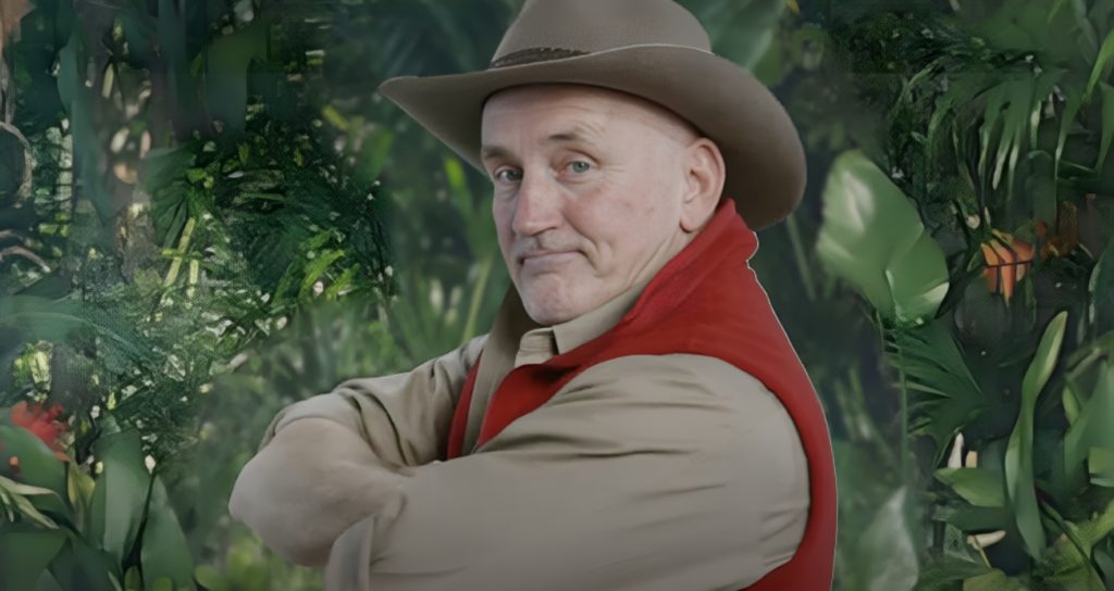 Barry McGuigan looks at camera from the side with his arms crossed on I'm A Celebrity... Get Me Out Of Here!