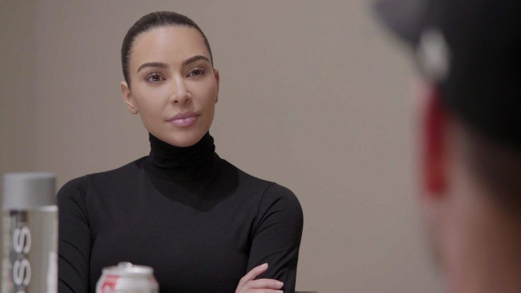 Kim Kardashian looks across shot with arms folded on The Kardashians