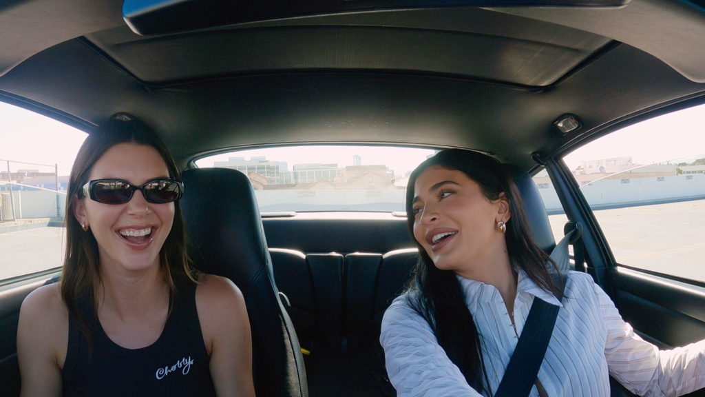 Kendall and Kylie Jenner laugh together in car filming The Kardashians