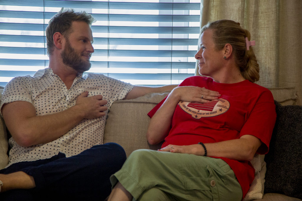 Bobby Berk holds heart while looking at Jody Castellucci, who also touches her chest on Queer Eye.
