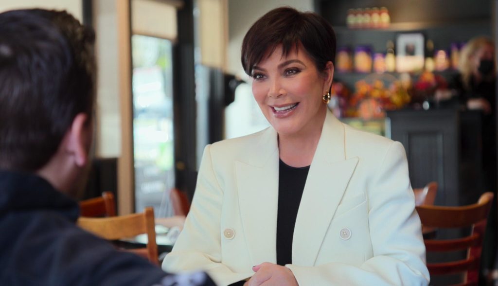 Kris Jenner smiles wearing cream blazer